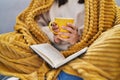 Young hispanic woman reading book and drinking coffee at home Royalty Free Stock Photo