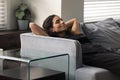 Young hispanic woman reclining on comfy couch with closed eyes Royalty Free Stock Photo