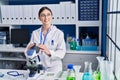 Young hispanic woman scientist using microscope at laboratory Royalty Free Stock Photo