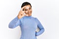 Young hispanic woman with short hair standing over isolated background smiling and confident gesturing with hand doing small size Royalty Free Stock Photo