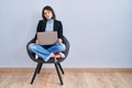 Young hispanic woman sitting on chair using computer laptop looking sleepy and tired, exhausted for fatigue and hangover, lazy Royalty Free Stock Photo
