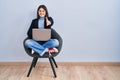 Young hispanic woman sitting on chair using computer laptop smiling friendly offering handshake as greeting and welcoming Royalty Free Stock Photo