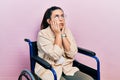 Young hispanic woman sitting on wheelchair tired hands covering face, depression and sadness, upset and irritated for problem Royalty Free Stock Photo