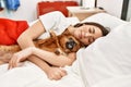 Young hispanic woman sleeping and hugging dog lying on bed at bedroom Royalty Free Stock Photo