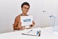 Young hispanic woman smiling confident holding vote banner at electoral college