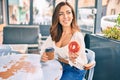 Young hispanic woman smiling happy having breakfast at coffee shop terrace Royalty Free Stock Photo