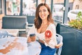 Young hispanic woman smiling happy having breakfast at coffee shop terrace Royalty Free Stock Photo