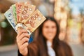Young hispanic woman smiling happy holding canadian dollars at the city Royalty Free Stock Photo