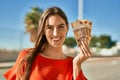 Young hispanic woman smiling happy holding hungarian forint banknotes at the city