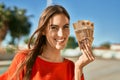 Young hispanic woman smiling happy holding hungarian forint banknotes at the city