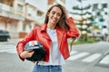 Young hispanic woman smiling happy holding moto helmet at the city Royalty Free Stock Photo