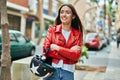 Young hispanic woman smiling happy holding moto helmet at the city Royalty Free Stock Photo