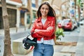 Young hispanic woman smiling happy holding moto helmet at the city Royalty Free Stock Photo