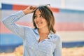 Young hispanic woman smiling happy touching her sunglasses at the city