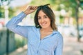 Young hispanic woman smiling happy touching her sunglasses at the park