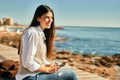 Young hispanic woman smiling happy using smartphone at the beach Royalty Free Stock Photo