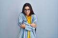 Young hispanic woman standing over blue background shaking and freezing for winter cold with sad and shock expression on face Royalty Free Stock Photo