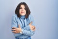 Young hispanic woman standing over blue background shaking and freezing for winter cold with sad and shock expression on face Royalty Free Stock Photo