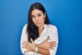 Young hispanic woman standing over blue background shaking and freezing for winter cold with sad and shock expression on face Royalty Free Stock Photo