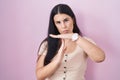 Young hispanic woman standing over pink background doing time out gesture with hands, frustrated and serious face Royalty Free Stock Photo