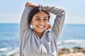 Young hispanic woman stretching arms training at seaside Royalty Free Stock Photo