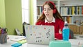 Young hispanic woman student using laptop and headphones studying at library university Royalty Free Stock Photo