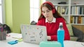 Young hispanic woman student using laptop and headphones studying at library university Royalty Free Stock Photo