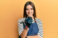 Young hispanic woman tattoo artist wearing professional uniform and gloves smiling with a happy and cool smile on face