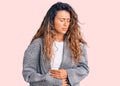 Young hispanic woman with tattoo wearing business oversize jacket with hand on stomach because indigestion, painful illness