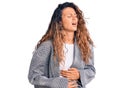 Young hispanic woman with tattoo wearing business oversize jacket with hand on stomach because nausea, painful disease feeling