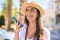 Young hispanic woman tourist talking on the smartphone eating ice cream at street Royalty Free Stock Photo