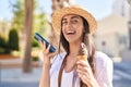 Young hispanic woman tourist talking on the smartphone eating ice cream at street Royalty Free Stock Photo