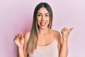 Young hispanic woman using file nail pointing thumb up to the side smiling happy with open mouth Royalty Free Stock Photo