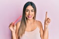 Young hispanic woman using file nail smiling with an idea or question pointing finger with happy face, number one Royalty Free Stock Photo