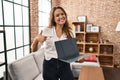 Young hispanic woman using laptop showing blank screen at home smiling happy and positive, thumb up doing excellent and approval Royalty Free Stock Photo