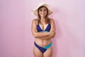 Young hispanic woman wearing bikini over pink background happy face smiling with crossed arms looking at the camera Royalty Free Stock Photo