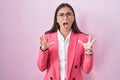Young hispanic woman wearing business clothes and glasses crazy and mad shouting and yelling with aggressive expression and arms Royalty Free Stock Photo