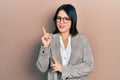 Young hispanic woman wearing business clothes and glasses smiling happy pointing with hand and finger to the side Royalty Free Stock Photo