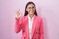 Young hispanic woman wearing business clothes and glasses smiling positive doing ok sign with hand and fingers Royalty Free Stock Photo