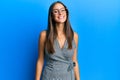 Young hispanic woman wearing business dress and glasses looking positive and happy standing and smiling with a confident smile Royalty Free Stock Photo