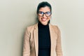 Young hispanic woman wearing business style and glasses looking positive and happy standing and smiling with a confident smile Royalty Free Stock Photo