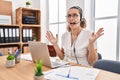 Young hispanic woman wearing call center agent headset at the office crazy and mad shouting and yelling with aggressive expression Royalty Free Stock Photo