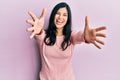 Young hispanic woman wearing casual clothes looking at the camera smiling with open arms for hug Royalty Free Stock Photo