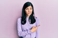 Young hispanic woman wearing casual clothes pointing aside worried and nervous with forefinger, concerned and surprised expression