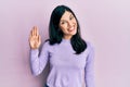 Young hispanic woman wearing casual clothes waiving saying hello happy and smiling, friendly welcome gesture