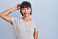 Young hispanic woman wearing casual t shirt over blue background confuse and wonder about question Royalty Free Stock Photo