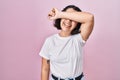 Young hispanic woman wearing casual white t shirt over pink background covering eyes with arm smiling cheerful and funny Royalty Free Stock Photo