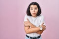 Young hispanic woman wearing casual white t shirt over pink background shaking and freezing for winter cold with sad and shock Royalty Free Stock Photo