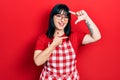 Young hispanic woman wearing cook apron and glasses smiling making frame with hands and fingers with happy face Royalty Free Stock Photo