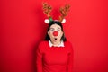 Young hispanic woman wearing deer christmas hat and red nose afraid and shocked with surprise and amazed expression, fear and Royalty Free Stock Photo
